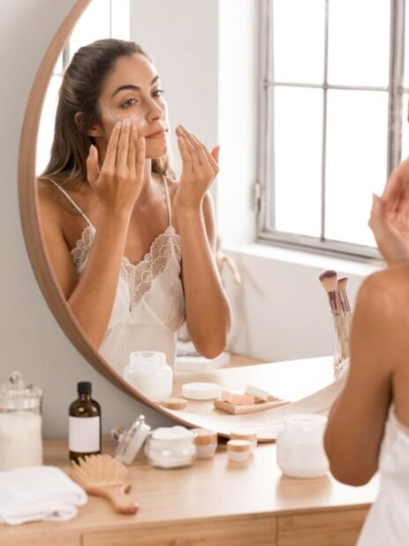 woman-applying-cream-mirror (1)